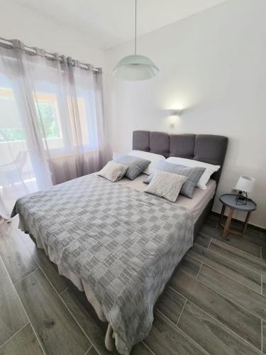a bedroom with a large bed with a gray blanket at Apartman Marijana in Pakoštane