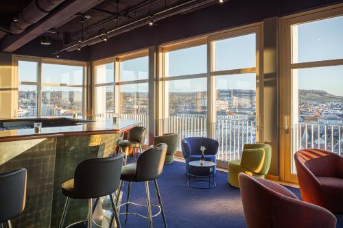 a bar in a room with chairs and windows at Parkhotel Heilbronn in Heilbronn