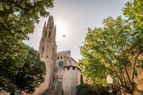 an old building with a tower and a church at BYPILLOW The Bloom in Girona
