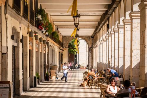 a hallway of a building with people sitting at tables at BYPILLOW The Bloom in Girona