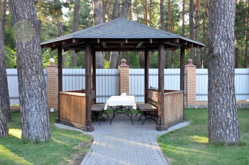 a wooden gazebo with a table in the middle of a garden at Hotel-Restaurant Complex Vensky in Brovary
