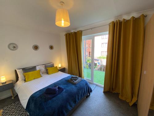 ein Schlafzimmer mit einem Bett und einem großen Fenster in der Unterkunft Marie’s 3 bedrooms Shakespeare house in Bedford