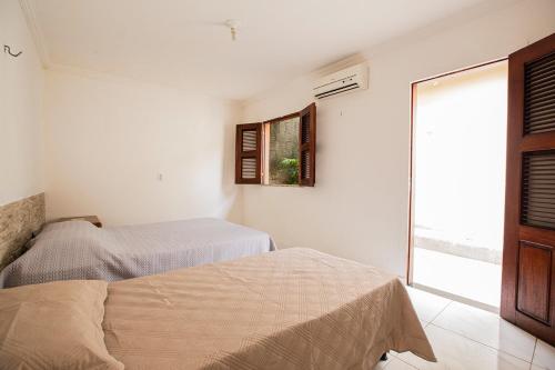 A bed or beds in a room at Porto das Dunas Casa Temporada Estilo e Conforto 2