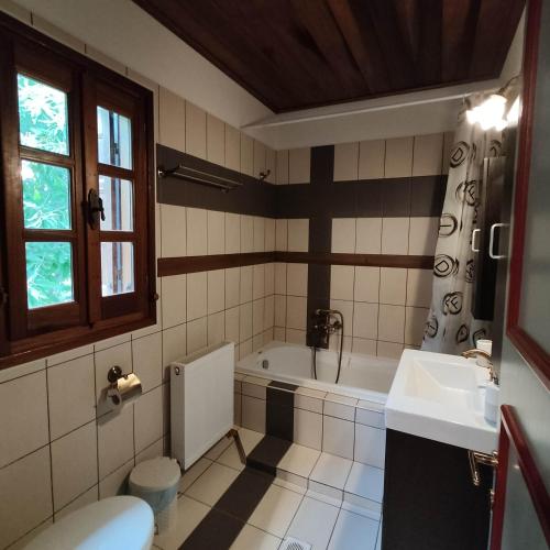 a bathroom with a bath tub and a sink at Vrionis House in Agios Dimitrios