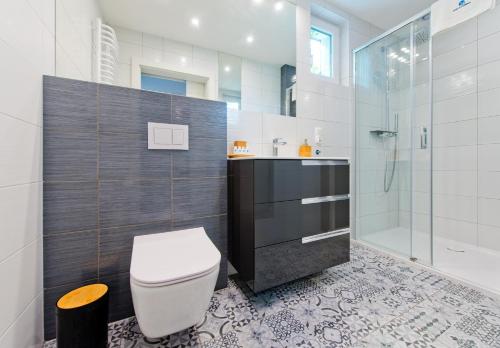 a bathroom with a toilet and a glass shower at Domek przy promenadzie in Kołobrzeg