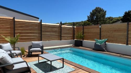 - une piscine dans un jardin avec une clôture en bois dans l'établissement L'Ayucca, à Saint-Jean-de-Monts