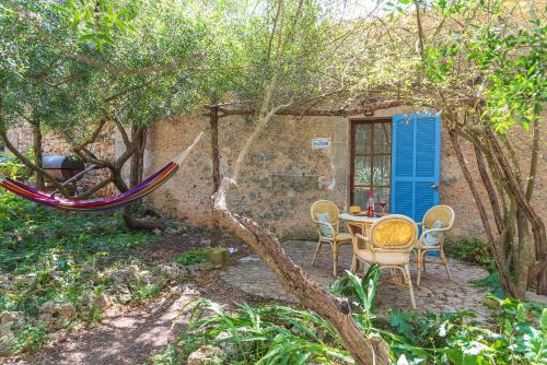 a hammock in a garden with a table and chairs at Sa Casa Rotja in Sineu
