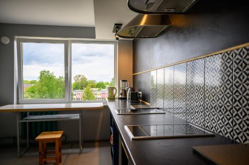 uma cozinha com um lavatório e uma janela em Liepu Hostelis em Liepāja