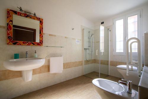 a bathroom with a sink and a toilet and a mirror at I Due Orfici in Cona