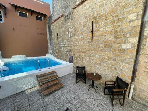 Utopia Luxury Suites - Old Town في بلدة رودس: حوض استحمام كبير جالس بجانب جدار من الطوب