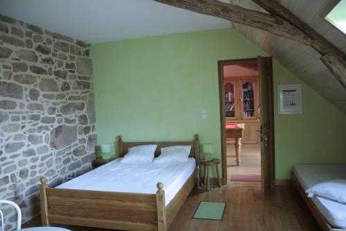une chambre avec un lit et un mur en pierre dans l'établissement Gîtes de Lez, à Laguépie