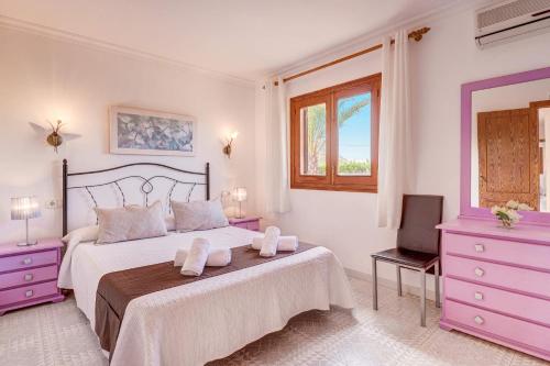 a white bedroom with a large bed with purple furniture at Villa Bauza by Villa Plus in El Port