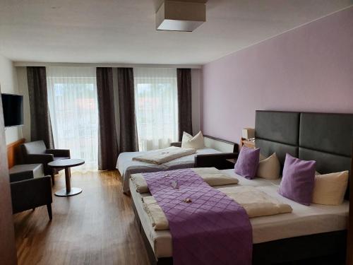Habitación de hotel con 2 camas y sofá en Boutique Hotel Beckenlehner en Unterhaching