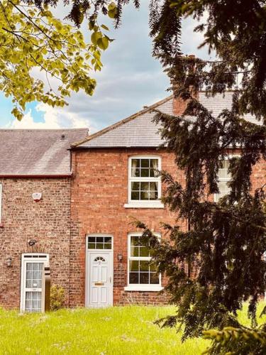 een stenen huis met een witte deur en ramen bij Church View, dog friendly, with parking, in Bolton Percy