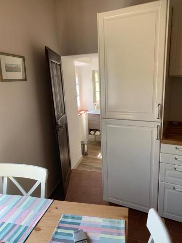 a kitchen with a white refrigerator and a table at In piazza Casale Marittimo in Casale Marittimo