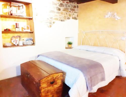 una camera con un letto bianco e un tronco in legno di Il Bugigattolo a Castagneto Carducci