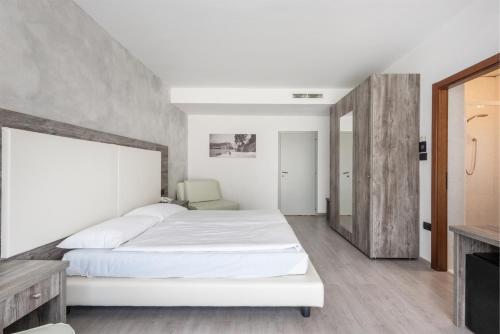 a bedroom with a large white bed in a room at Hotel De Nac in Nago-Torbole