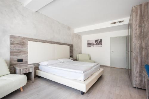 a bedroom with two beds and a couch at Hotel De Nac in Nago-Torbole