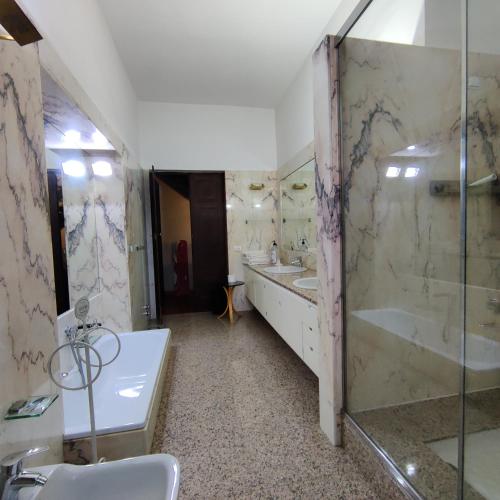 Un baño con dos lavabos, una bañera y una ducha. en Villa Ghia, en Parma