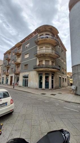 Un gran edificio con un coche aparcado delante. en Sa Cannacca-Guest House, en Olbia