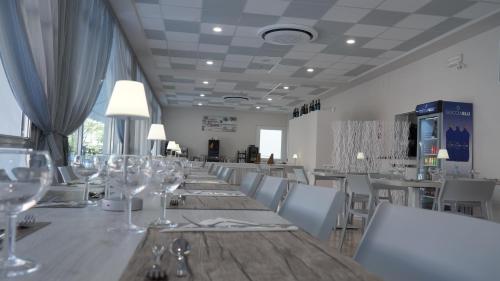 una sala da pranzo con un lungo tavolo con bicchieri da vino di Lively Hotel a Bellaria-Igea Marina