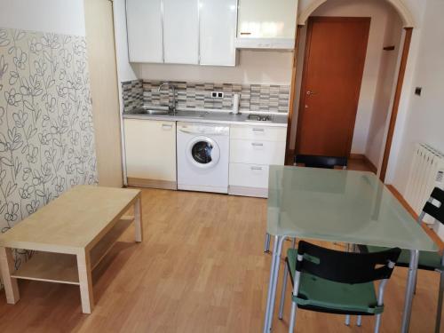 uma cozinha com uma mesa e uma máquina de lavar roupa em Apartamento Playa Victoria em Cádiz