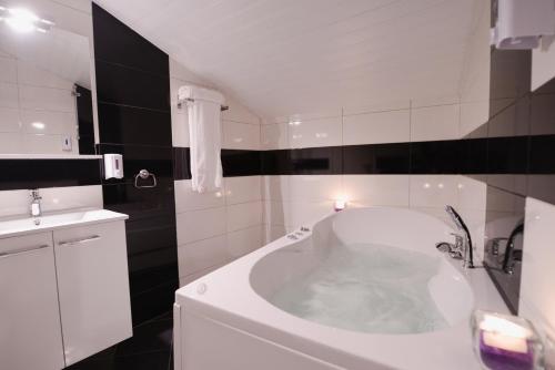 a bathroom with a tub and a sink at Millenium Travel Apartments in Bitola