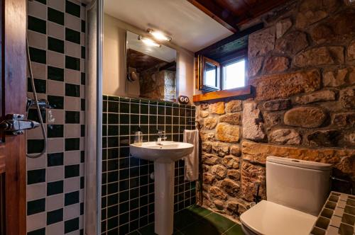 a bathroom with a sink and a stone wall at Casa Rural Ángela 1 in Villanueva de la Peña