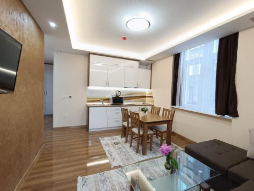 eine Küche und ein Wohnzimmer mit einem Tisch und Stühlen in der Unterkunft KARAULA Apartments in Sarajevo