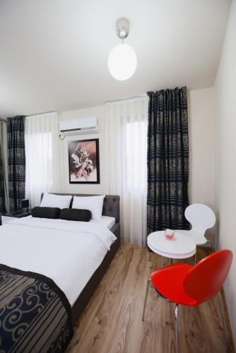 a bedroom with a bed and a red chair at Millenium Travel Apartments in Bitola
