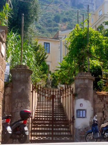 a gate with a scooter parked in front of a house at Lux Aurea in Meta