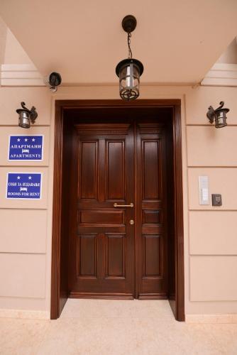 a wooden door in a building with a sign on it at Millenium Travel Apartments in Bitola