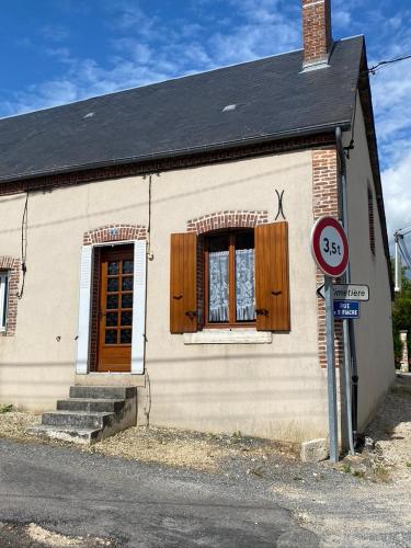 Cette petite maison dispose de 2 fenêtres et d'un panneau indiquant la rue. dans l'établissement Maison typique de sologne, à La Chapelle-dʼAngillon
