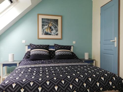 une chambre avec un lit avec une couette noire et blanche dans l'établissement FACE A LA MER, à Fouesnant