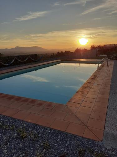 una piscina con puesta de sol en el fondo en Casa Musa, en Capannori