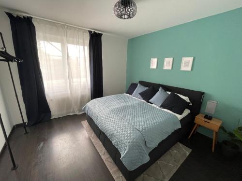 a bedroom with a bed with blue walls and a window at Airport Apartment für 4 - Smart TV - Küche - eCharger in Hamburg