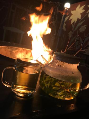 a glass mug of tea next to a fire at Apple Tree Family Home (ECO) in Dzorakap