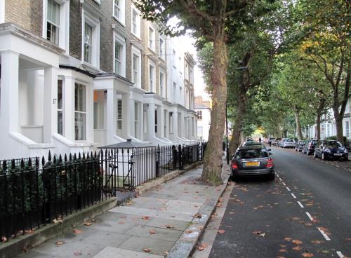 a car parked on the side of a street next to houses at Boutique Barclay House London townhouse - West London, Kensington, Chelsea, Fulham in London