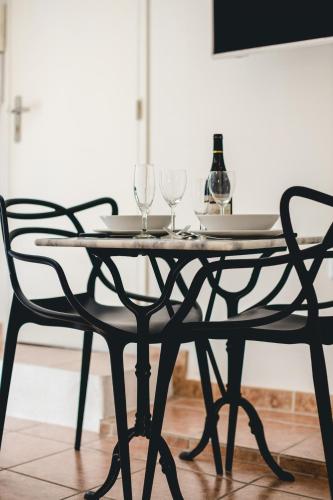 a table with two chairs and two wine glasses on it at Les Précieuses Suites & Spa I in Avignon
