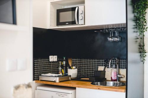 a kitchen with a sink and a microwave at Les Précieuses Suites & Spa I in Avignon