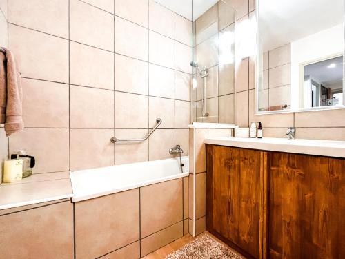 a bathroom with a tub and a sink and a mirror at Large 2-Bedroom Apartment, Centre of Flaine Foret in Flaine