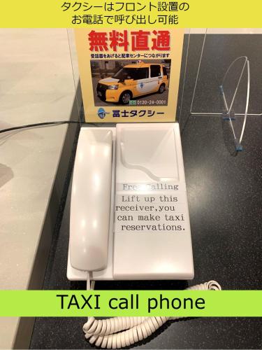atax call phone with a toilet in front of a box at Henn na Hotel Kanazawa Korimbo in Kanazawa