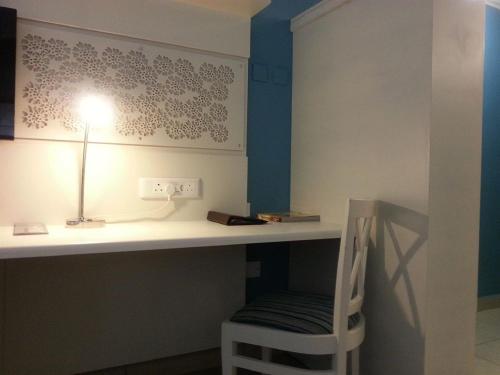 un escritorio con una lámpara y una silla debajo en Peermont Metcourt Hotel, en Francistown
