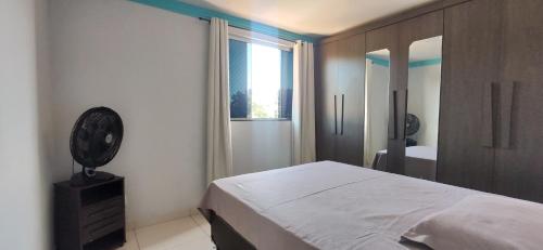 a bedroom with a bed and a window and a mirror at Apartamento Mobiliado, Parque Atheneu. in Goiânia