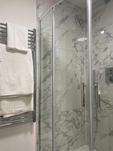 a bathroom with a shower with a glass at Peak Willow Apartments in Leek