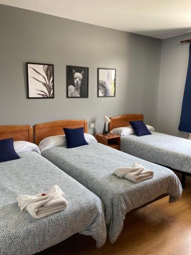 a bedroom with two beds with towels on them at Hostal La Concha Somo in Somo