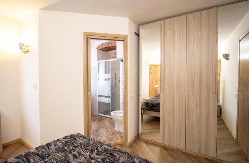a bedroom with a mirror and a bathroom with a toilet at La primula della Valle Soana in Ronco Canavese