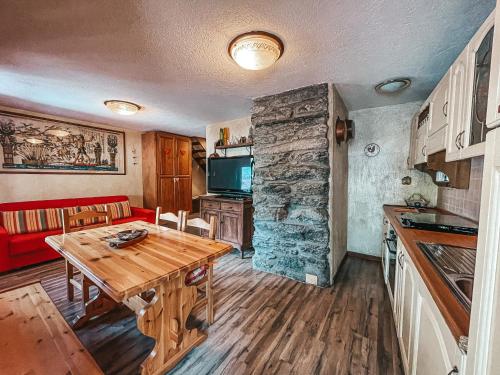 eine Küche und ein Esszimmer mit einem Holztisch in einem Zimmer in der Unterkunft Casa Netto in Morgex