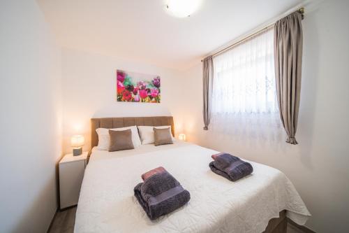 een slaapkamer met een groot bed met twee kussens erop bij Leonardo House in Novigrad Istria