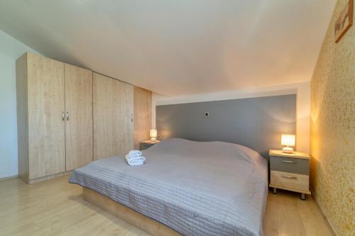 1 dormitorio con 1 cama blanca y 2 mesitas de noche en Apartmani Olga en Bibinje